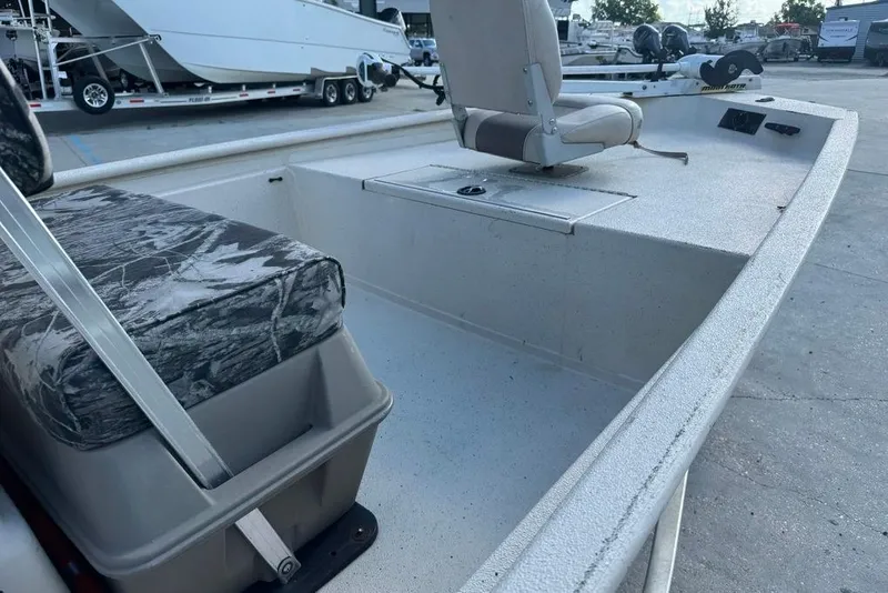 Slide: The Image of 2010 Xpress XP18 boat interior with camo seating and console, displayed outdoors. - 16