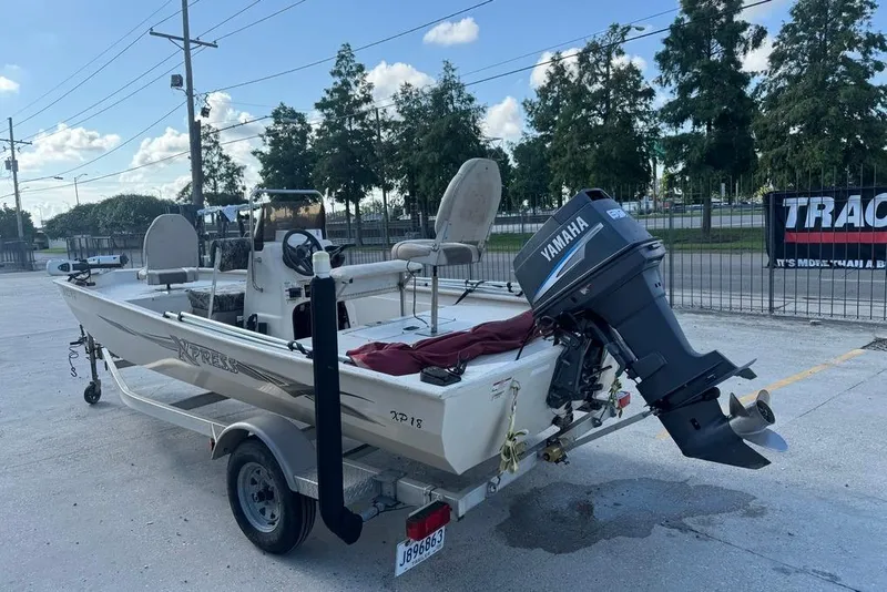 Slide: The Image of 2010 Xpress XP18 boat with Yamaha outboard motor on trailer, parked outdoors. - 5