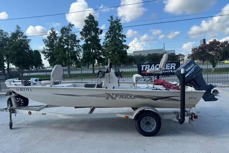 Slide: The Image of 2010 Xpress XP18 boat on trailer with Yamaha motor, parked outdoors. - 6