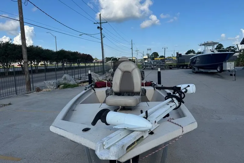 Slide: The Image of 2010 Xpress XP18 boat with trolling motor, parked outdoors under a clear blue sky. - 8