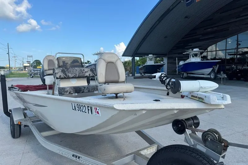 Slide: The Image of 2010 Xpress XP18 boat with seating and trolling motor in a parking area. - 9