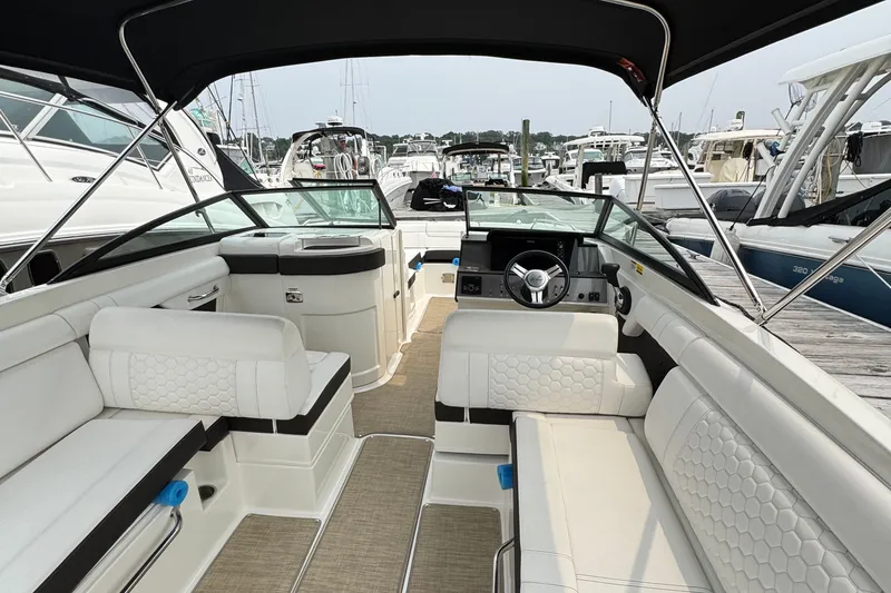 Slide: The Image of 2018 Sea Ray SDX 270 Outboard boat interior with white seating and steering wheel. - 14