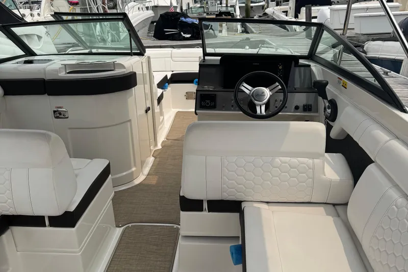 Slide: The Image of 2018 Sea Ray SDX 270 Outboard boat interior with white seating and steering wheel. - 15