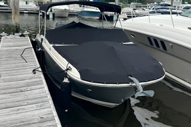 Slide: The Image of 2018 Sea Ray SDX 270 Outboard boat docked with cover on, marina background. - 2