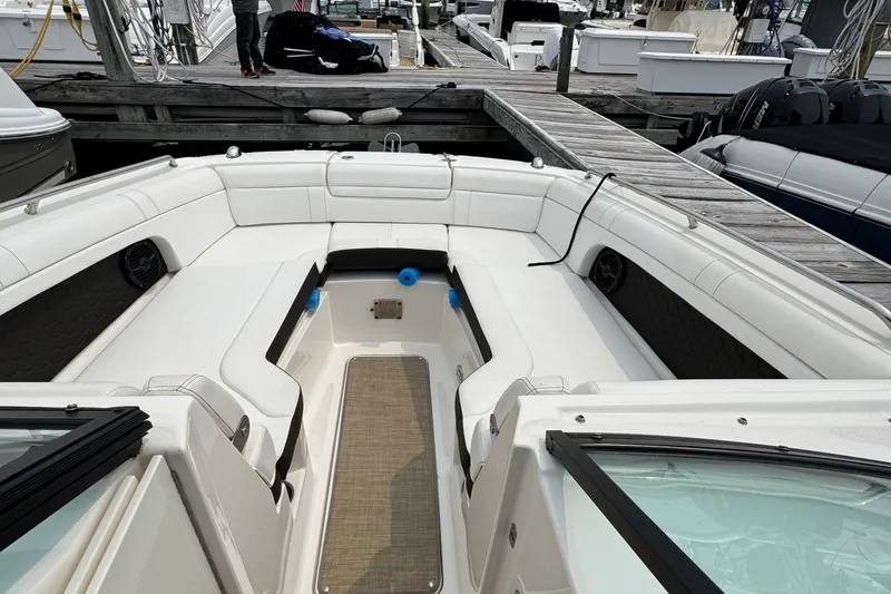 Slide: The Image of 2018 Sea Ray SDX 270 Outboard boat interior with white seating at a marina. - 4