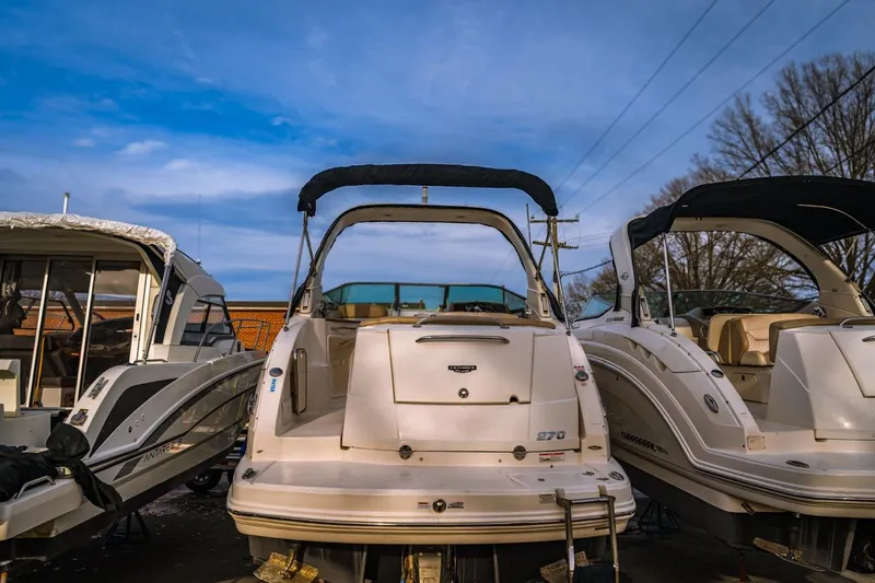 Slide: The Image of 2018 Chaparral 270 Signature boat docked, rear view, under a clear blue sky. - 3