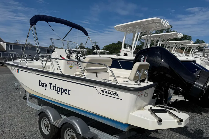The Image of 2024 Boston Whaler 190 Montauk boat named "Day Tripper" on a trailer, sunny day. - 0