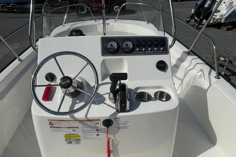 Slide: The Image of 2024 Boston Whaler 190 Montauk boat console with steering wheel and controls. - 4