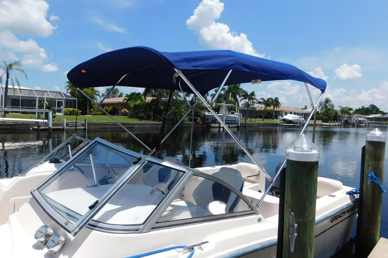 Slide: The Image of 2008 Grady-White Tournament 205 boat docked with blue canopy on a sunny day. - 4