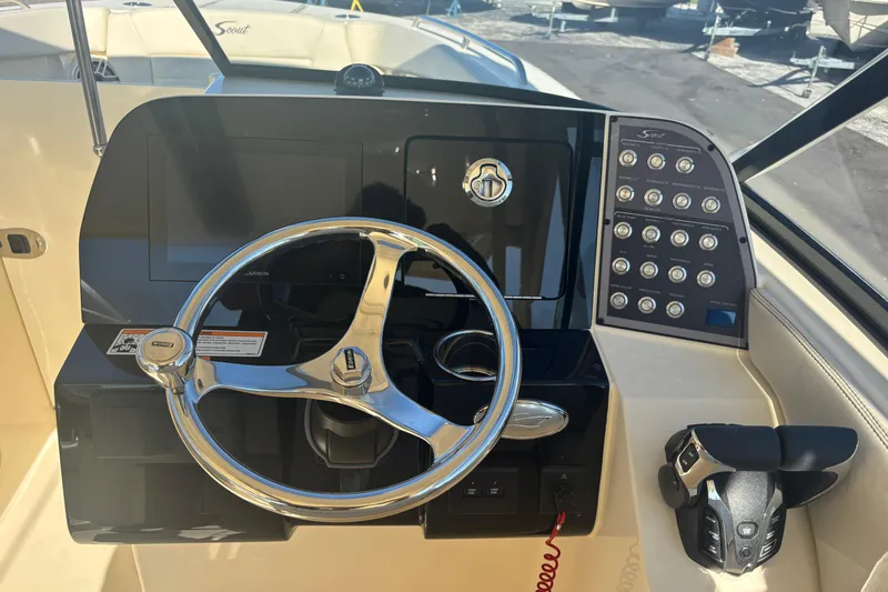 Slide: The Image of 2026 Scout 255 Dorado boat dashboard with steering wheel and control panel. - 12