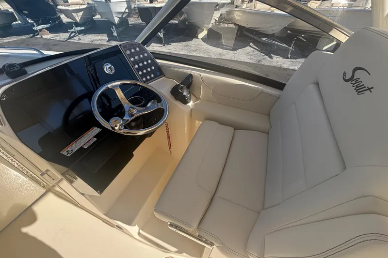 Slide: The Image of 2026 Scout 255 Dorado boat interior with steering wheel and branded seating. - 13