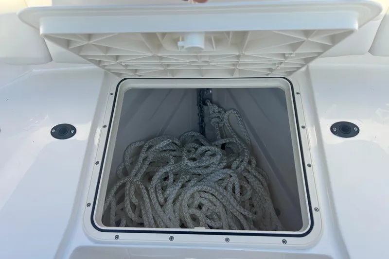 Slide: The Image of Open storage compartment on 2026 Scout 255 Dorado boat with coiled rope inside. - 28