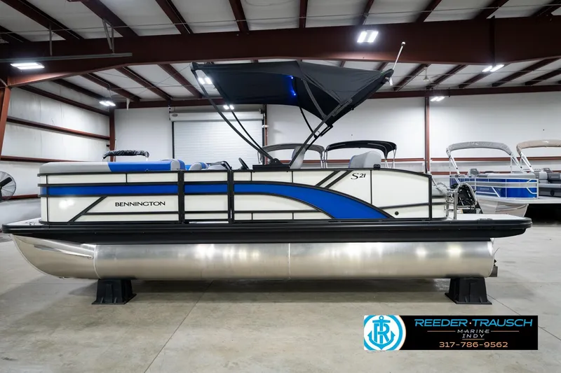 Slide: The Image of 2026 Bennington 21 SSB pontoon boat interior with blue and gray seating, showcased by Reeder-Trausch Marine. - 10