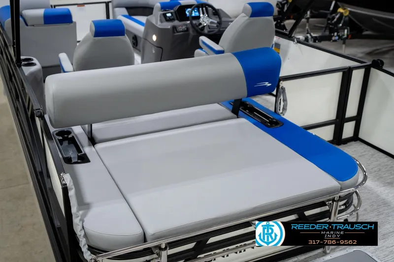 Slide: The Image of 2026 Bennington 21 SSB pontoon boat interior with blue and gray seating in showroom. - 14