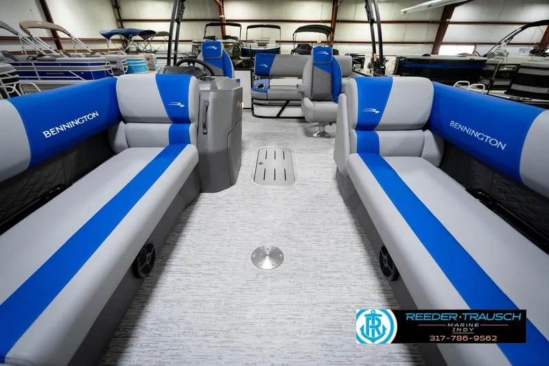 Slide: The Image of 2026 Bennington 21 SSB pontoon boat interior with blue and gray seating in showroom. - 15