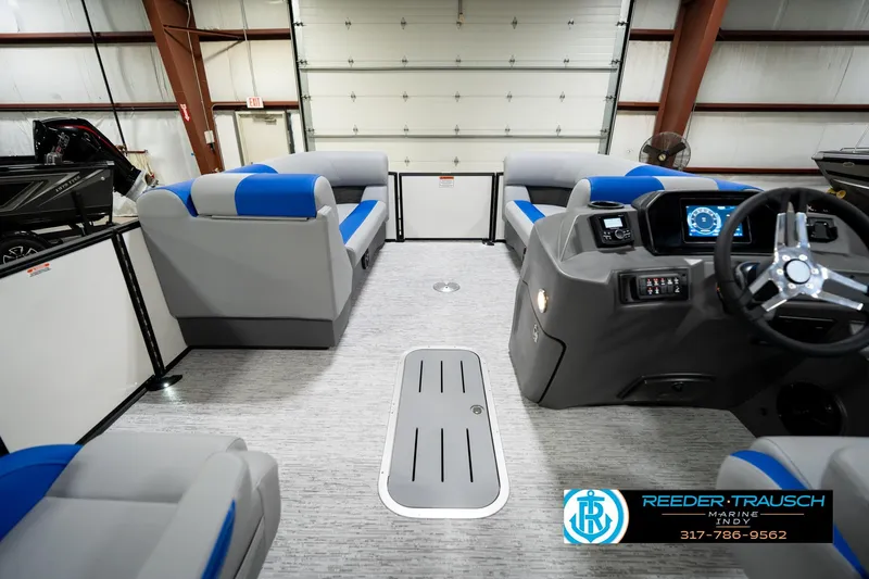 Slide: The Image of 2026 Bennington 21 SSB pontoon boat interior with blue and gray seating in a showroom. - 19