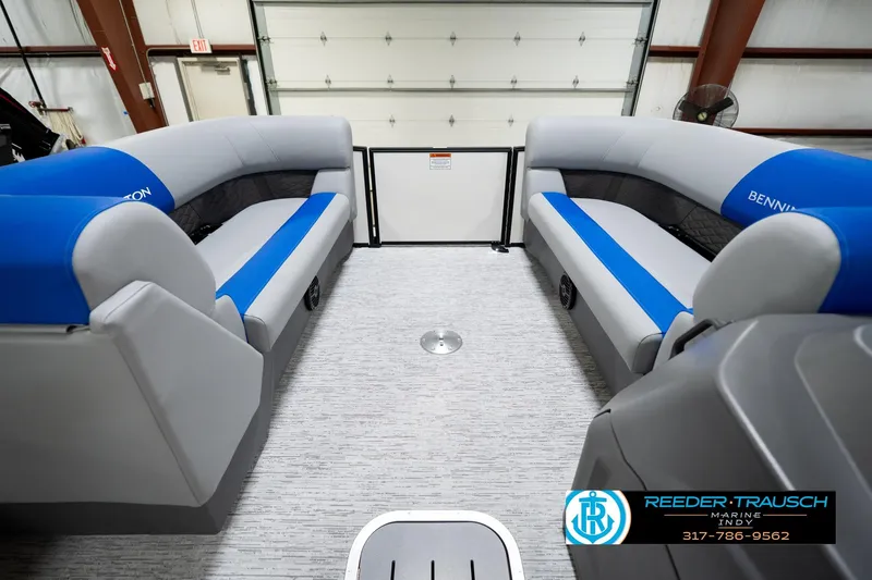 Slide: The Image of 2026 Bennington 21 SSB pontoon boat interior with blue and gray seating in a showroom. - 20