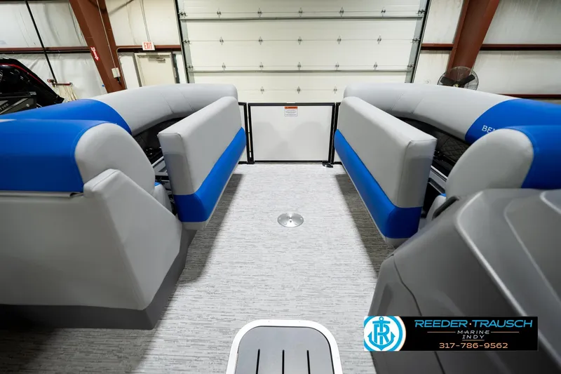 Slide: The Image of 2026 Bennington 21 SSB pontoon boat interior with blue and gray seating in showroom. - 22