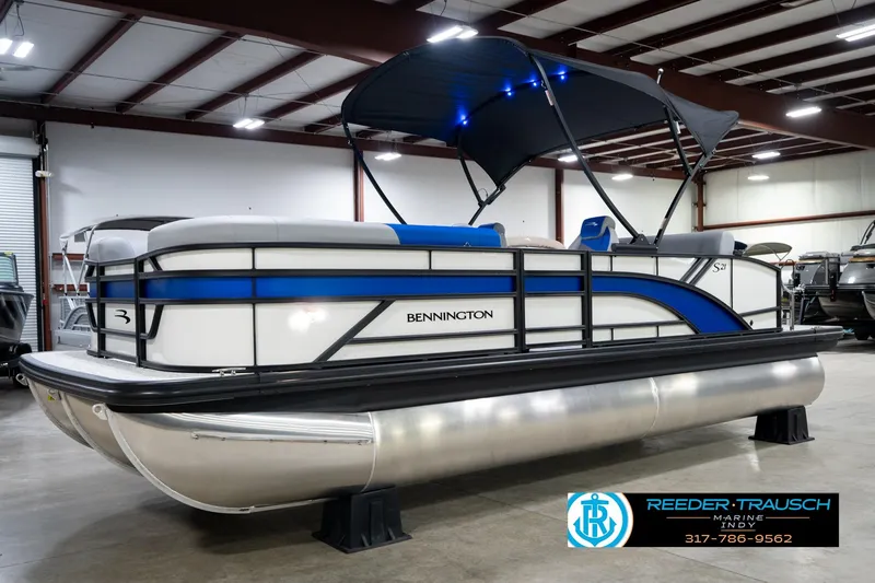 Slide: The Image of 2026 Bennington 21 SSB pontoon boat in showroom, featuring sleek design and blue accents. - 3