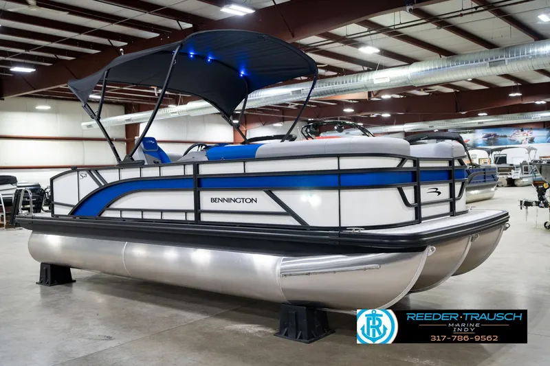 Slide: The Image of 2026 Bennington 21 SSB pontoon boat in showroom, featuring sleek design and blue accents. - 5