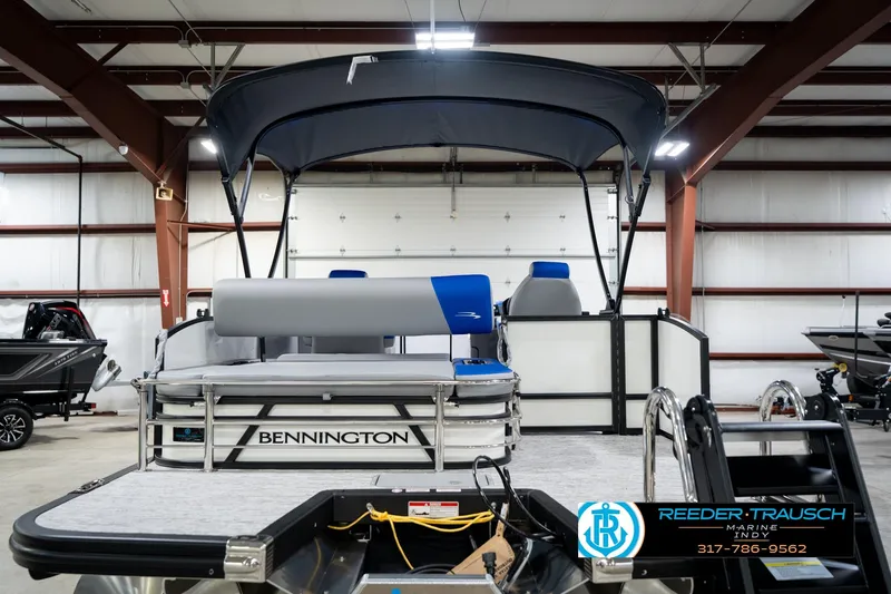 Slide: The Image of 2026 Bennington 21 SSB pontoon boat in showroom, featuring blue and white design. - 8