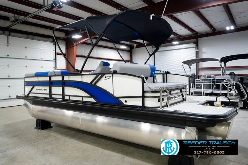 Slide: The Image of 2026 Bennington 21 SSB pontoon boat in showroom, featuring sleek design and blue accents. - 9