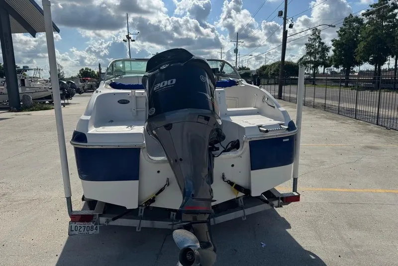 Slide: The Image of 2006 NauticStar 210 DC Sport Deck boat with Yamaha 200 outboard motor, parked outdoors. - 4