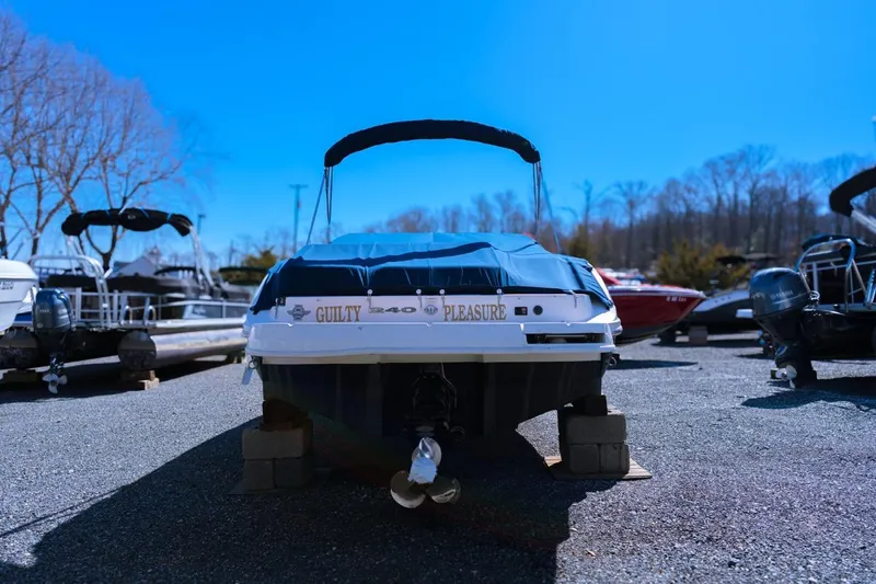 Slide: The Image of 2013 Sea Ray 240 Sundancer boat on dry dock under clear blue sky. - 3