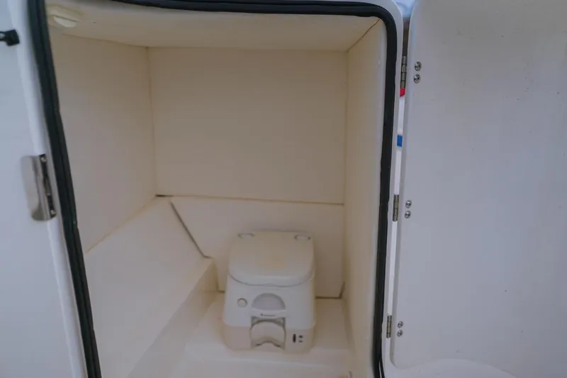 Slide: The Image of 2013 Sea Ray 240 Sundancer boat interior with compact marine toilet. - 6