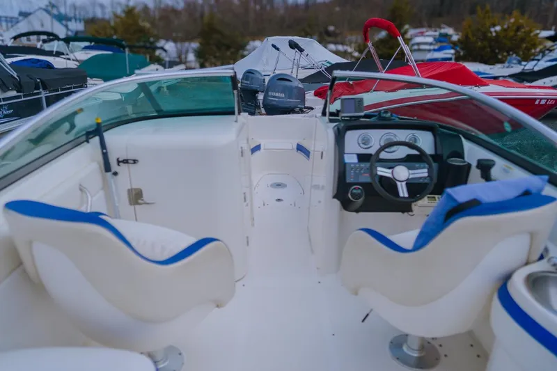 Slide: The Image of 2013 Sea Ray 240 Sundancer boat interior with steering wheel and seating. - 8