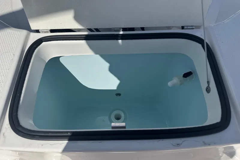 Slide: The Image of 2025 Robalo R180 Center Console livewell with open lid, showcasing interior features. - 10