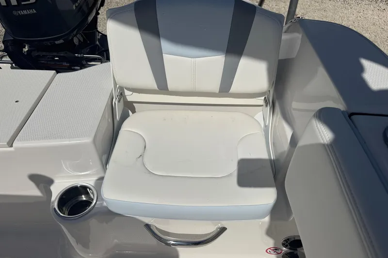 Slide: The Image of 2025 Robalo R180 Center Console boat seat with white upholstery and cup holder. - 9