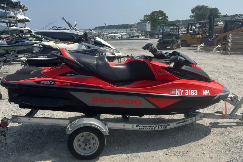 Slide: The Image of 2016 Sea-Doo RXT-X 300 jet ski on trailer in marina setting. - 4