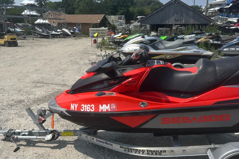 Slide: The Image of 2016 Sea-Doo RXT-X 300 jet ski on trailer in a marina setting. - 8