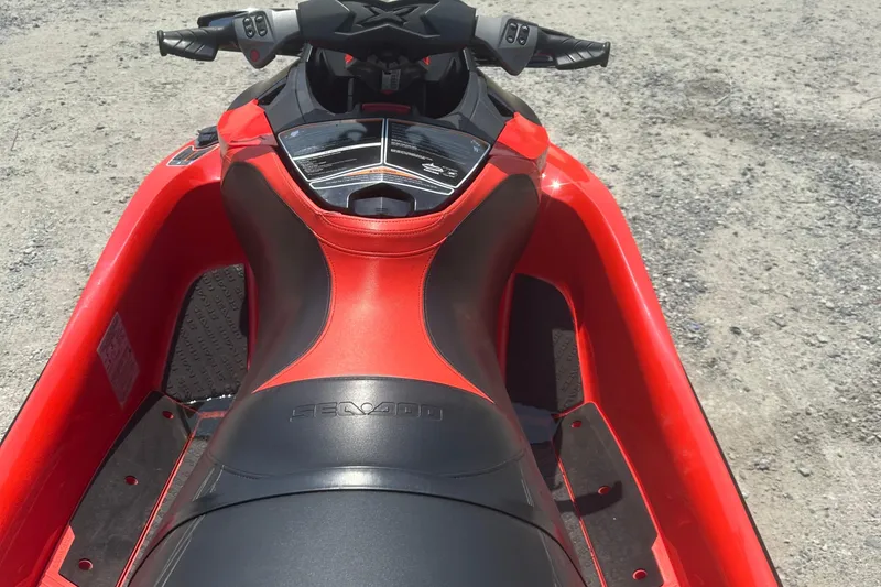 Slide: The Image of 2016 Sea-Doo RXT-X 300 jet ski, red and black, parked on gravel. - 9