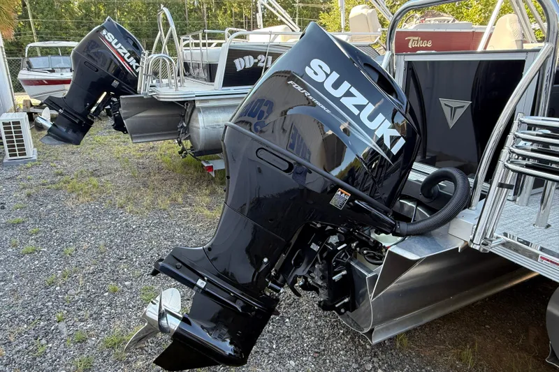 Slide: The Image of 2026 Tahoe Pontoon Geofish RF with Suzuki outboard motors, parked on gravel. - 5