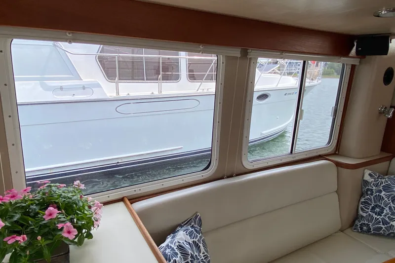 Slide: The Image of Interior view of a 2003 American Tug 34, featuring a cozy seating area with floral decor. - 28