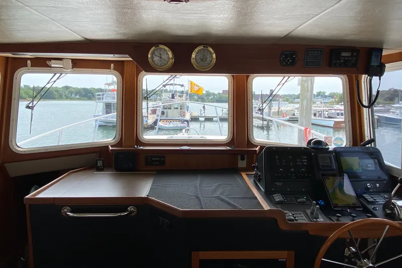 Slide: The Image of Pilothouse interior of 2003 American Tug 34, featuring navigation equipment and waterfront view. - 40