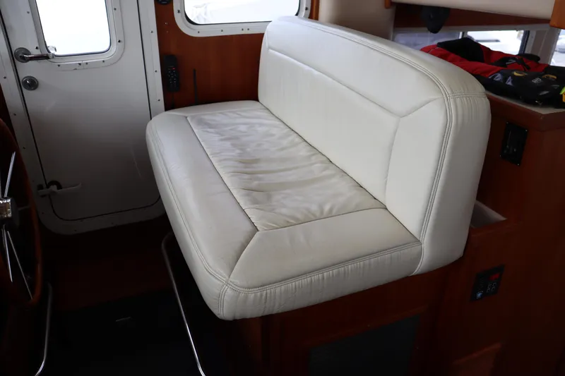 Slide: The Image of Interior of a 2003 American Tug 34, featuring a white leather bench seat. - 44