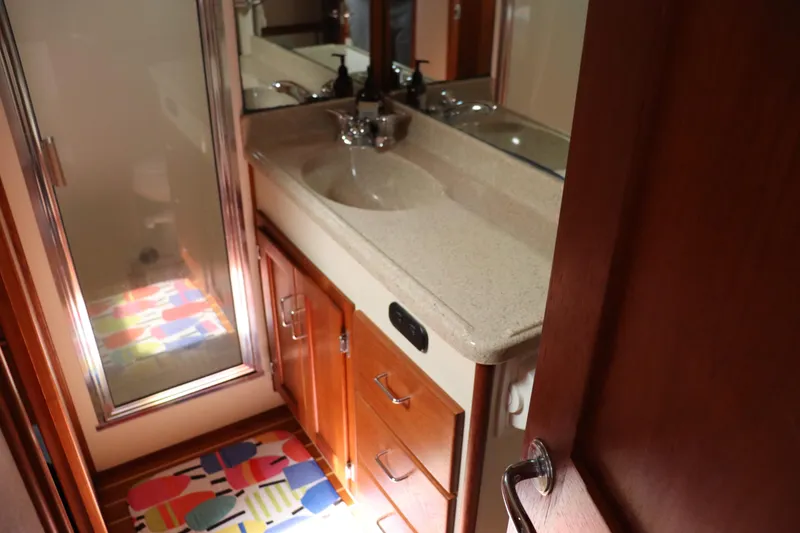 Slide: The Image of Bathroom interior of 2003 American Tug 34 with colorful rug and wooden cabinetry. - 49