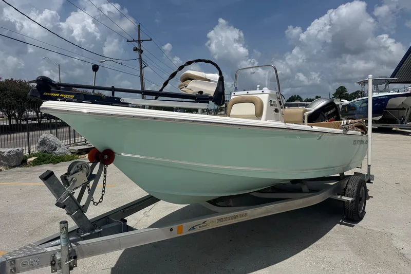 Slide: The Image of 2018 Key West 176 Bay Reef boat on trailer, parked outdoors under a cloudy sky. - 3