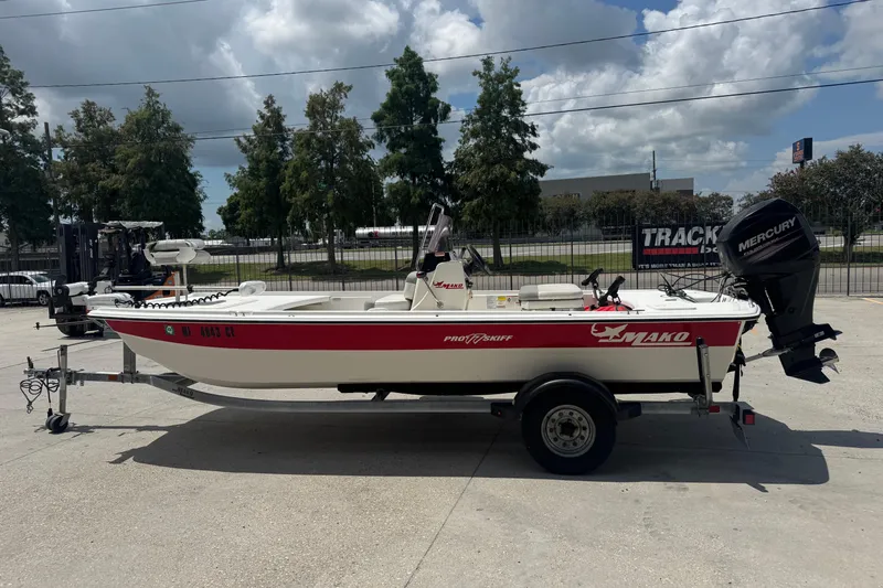 Slide: The Image of 2018 Mako Pro Skiff 17 CC boat on trailer, parked outdoors under cloudy sky. - 7