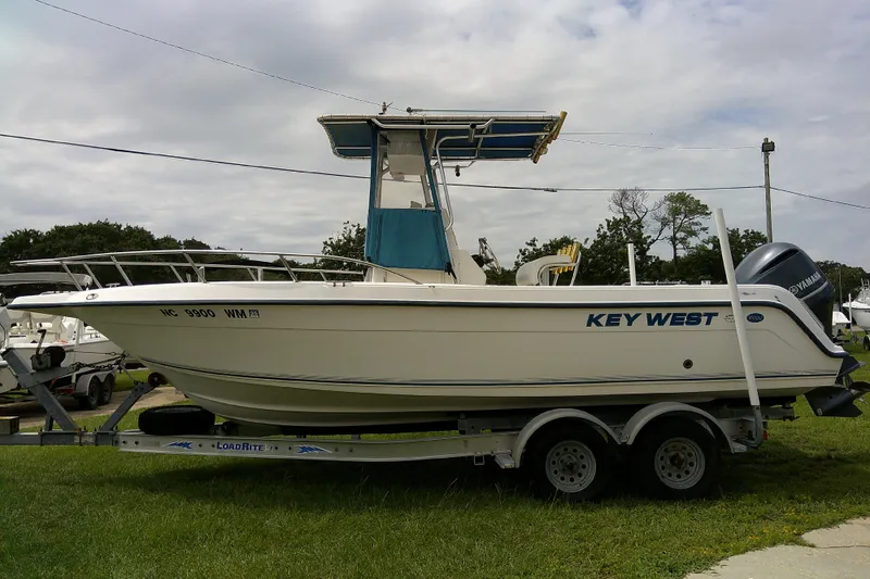 Slide: The Image of 2001 Key West boat on trailer with Yamaha motor, parked on grass under cloudy sky. - 1