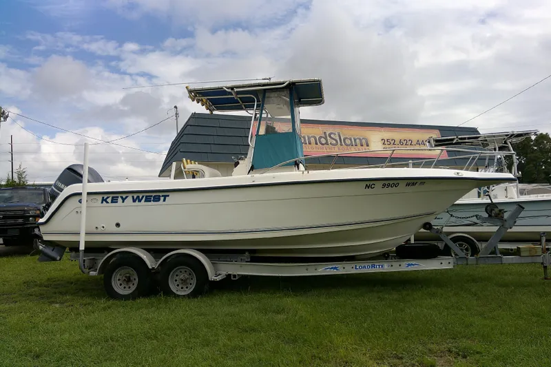 Slide: The Image of 2001 Key West boat on trailer, parked on grass under cloudy sky. - 4