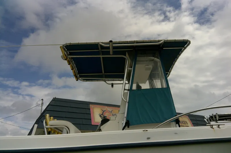 Slide: The Image of 2001 Key West boat with blue canopy against cloudy sky. - 5