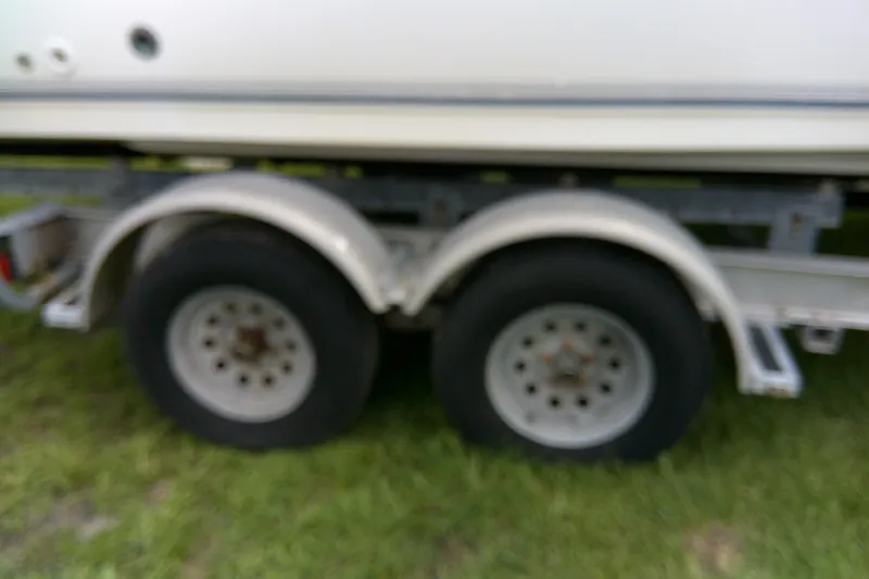 Slide: The Image of Trailer wheels of a 2001 Key West boat on grass. - 6