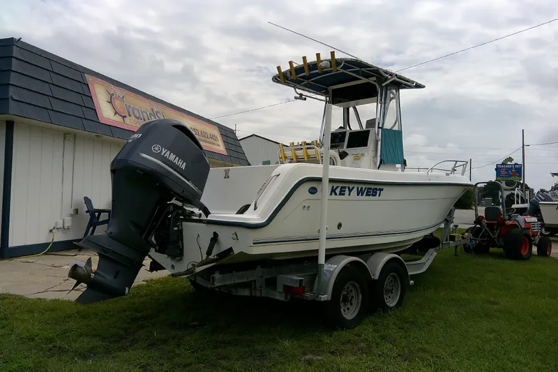 Slide: The Image of 2001 Key West boat with Yamaha motor on trailer, parked outside a building. - 7