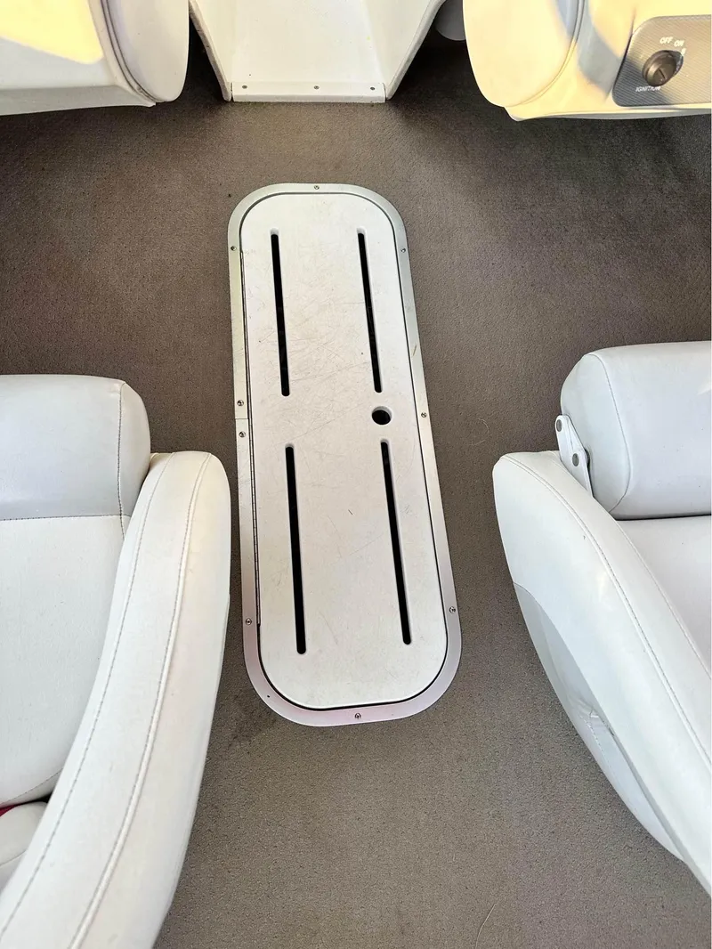 Slide: The Image of Interior of a 2007 Mariah FS18 boat, featuring white seating and a central storage compartment. - 11