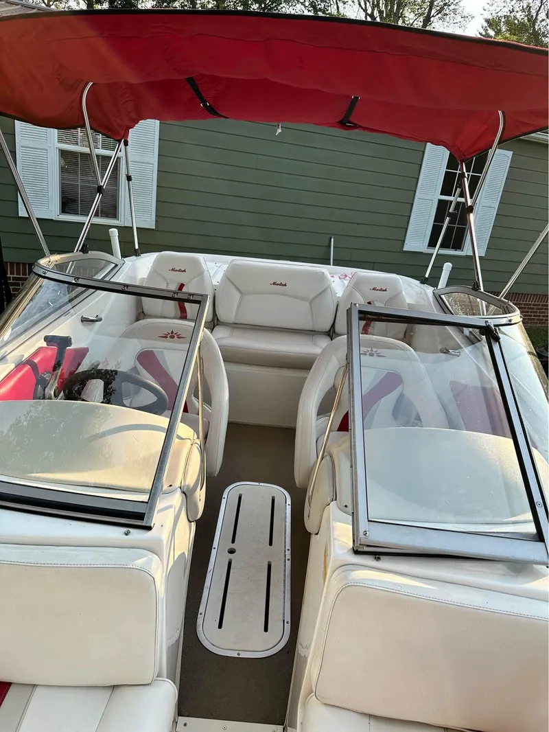 Slide: The Image of 2007 Mariah FS18 boat with red canopy and white seating, parked outdoors. - 7