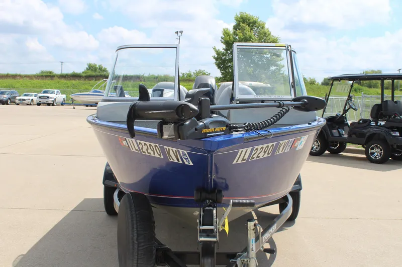 Slide: The Image of 2016 Tracker Pro Guide V-16 WT boat on trailer in parking lot. - 2